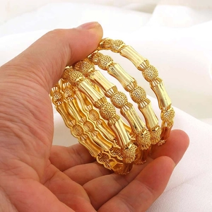 Detail van vier 18K vergulde holle armbanden met bamboestijl en sierlijke patronen