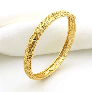 Dettaglio di un bracciale placcato oro 18k con intagli floreali traforati e trama a rete