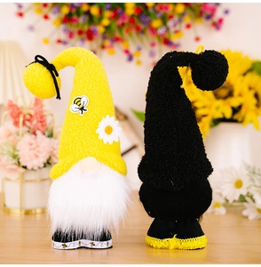 Macro detail of bee festival gnomes with knit yellow hats and floral daisy decorations