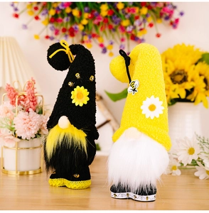 Close-up of handmade bee-themed gnomes with sunflowers and daisies in cozy indoor setting