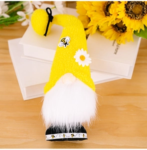 Close-up of a bee-themed gnome doll with yellow plush hat and daisy flower details