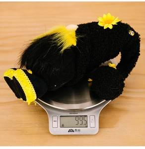 Detail shot of bee gnome plush toy on a digital scale weighing approximately 99.5 grams