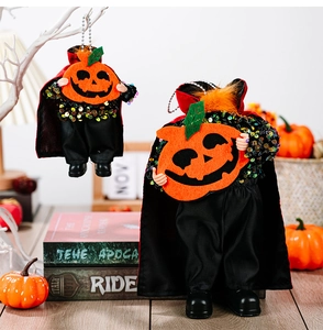 Detailed view of Halloween sequin vampire figurines with orange pumpkins on wooden desk