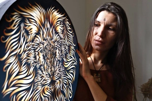 Detailed view of shamaic drum featuring a golden lion head design with artistic textures