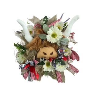 Rustic Highland Cow wreath detail with plush head, white daisies and colorful ribbons
