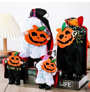 Detail of sequined Halloween headless devil dolls with capes and pumpkin felt lanterns