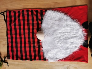 Detail der Weihnachts-Gnom-Geschenktüte mit Karomuster, Plüschbart und Kordelzugverschluss
