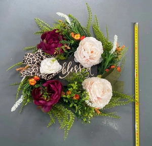 Detail of autumn wreath with peonies, leopard print ribbon and golden blessed sign