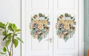Detail of Highland Cow wreath with white flowers and rustic bows on a white door