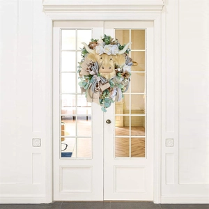 Rustic Highland Cow spring wreath with faux flowers and ribbons on a white door