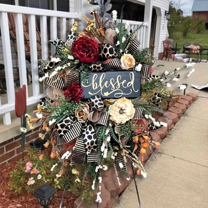 Close-up of fall wreath with mixed ribbons and a black plaque inscribed with blessed