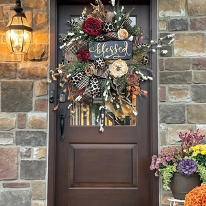 Detail of autumn wreath with blessed sign and leopard print ribbon on a wooden door