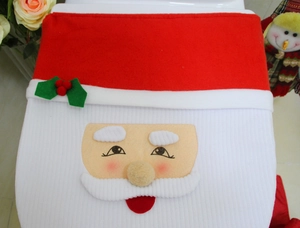 Detailed view of plush Santa Claus toilet seat cover with 3D beard and holly leaf accents