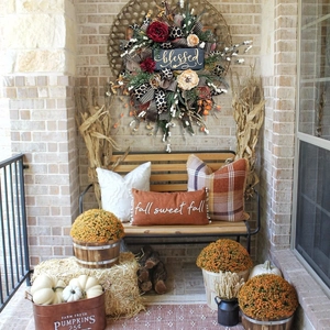Detail of autumn wreath with blessed plaque, leopard ribbons and fall porch decorations