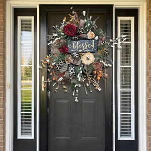 Close-up of autumn wreath with leopard ribbons and a golden Blessed wooden sign