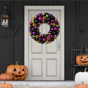 Ghirlanda di Halloween con palline colorate e zucche appesa a una porta bianca