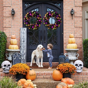 Set di ghirlande di Halloween con palline glitterate viola e zucche appese a una porta nera