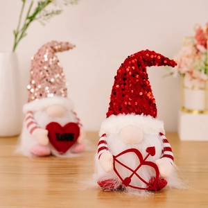 Paar leuchtende Valentinstag-Wichtel mit Pailletten und Herz-Accessoires auf Holztisch
