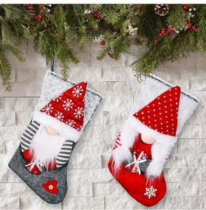 Close-up of gnome Christmas stockings with snowflake patterns on rustic stone background