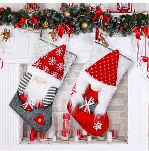 Detailed view of two Christmas gnome stockings hanging on a white decorated fireplace