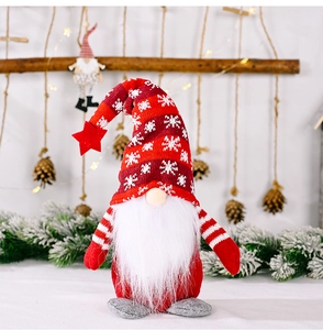 Close-up of knit Christmas gnome with white snowflake pattern and red star on hat