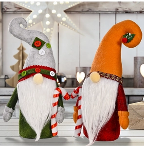 Detail of Christmas gnomes with felt hats and candy canes on a cozy wooden background