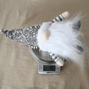 Close-up of sequined Christmas gnome gnome weighing 86.4g on a digital scale