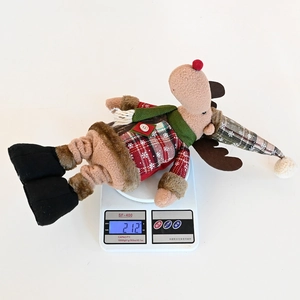 Detailed view of plush Christmas reindeer ornament weighing 212g on a scale