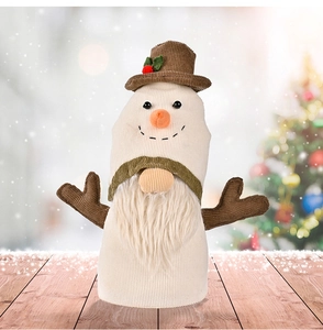 Close-up of a Christmas gnome doll with corduroy antlers on a warm wooden background
