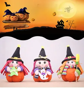 Detailed view of Halloween plush witch and pumpkin figurines with decorative broom and star