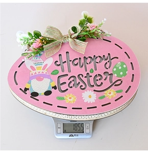 Close-up of Happy Easter wooden egg sign with lights on an electronic scale showing 185.5g weight