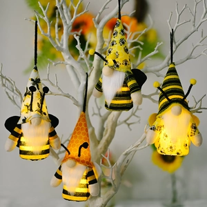 Set di quattro gnomi ape luminosi con strisce e ali appesi a un ramo di un albero decorato