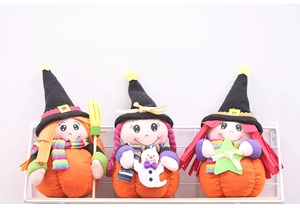 Detailed view of three Halloween witch plush dolls sitting on pumpkins with brooms