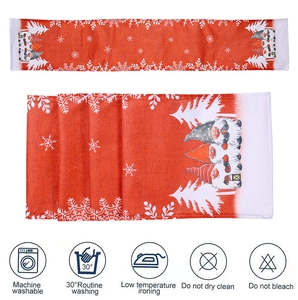 Detail of Christmas gnome table runner showing festive plaid fabric and washing care icons