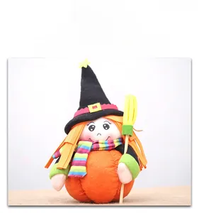 Detail showing a Halloween witch plush with star hat and broom on an orange pumpkin base