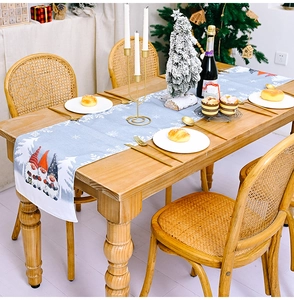 Detail of Christmas gnome table runner with snowflake pattern on a wooden dining table