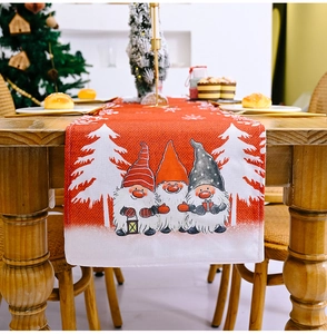 Close-up of red Christmas gnome table runner with white pine silhouettes on linen fabric