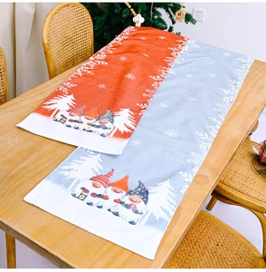 Close-up of Christmas table runner with gnomes and snowflakes on a wooden table