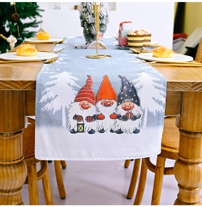 Detail of Christmas gnome table runner with forest motif on a wooden dining table