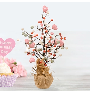Close-up of Mother's Day tabletop tree with pink hearts, colorful beads and LED lights