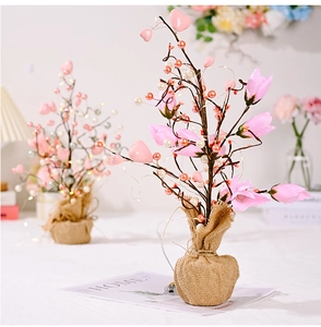 Close-up of lighted tulip tree decoration with pink flowers and hanging heart ornaments