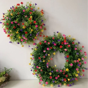 Couronne de fleurs artificielles de printemps avec fleurs colorées et feuilles vertes de porte