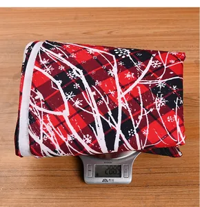 Detail of red and black buffalo plaid Christmas tree skirt showing fabric weight on scale