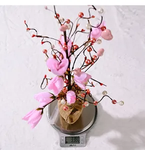 Detail shot of LED flower tree on a scale showing a product weight of 338 grams