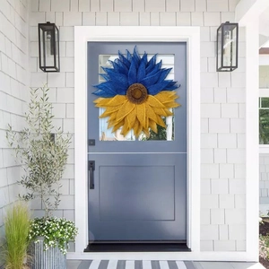 Blue and yellow sunflower door wreath decoration displayed on a gray wooden door