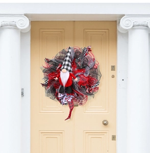 Detail van een kerstkrans met een kerstkabouter en rood-zwart deco-gaas aan een voordeur
