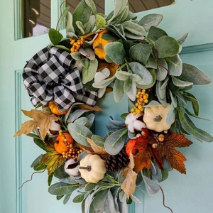 Herbstkranz mit Eukalyptus, Mini-Kürbissen und Karoschleife an blauer Holztür dekoriert