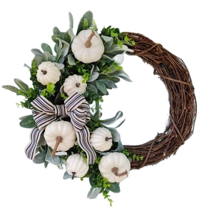 Herfstkrans met witte pompoenen, ezelsoorbladeren en een zwart-wit gestreepte strik