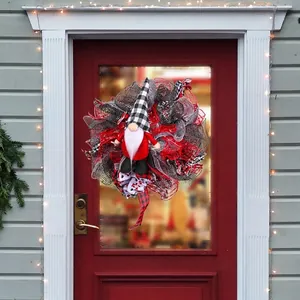 Kerstkrans met kerstkabouter en rood-zwarte linten voor feestelijke voordeurdecoratie