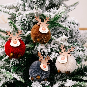 Ornements de renne de Noël en peluche en quatre couleurs sur un sapin enneigé